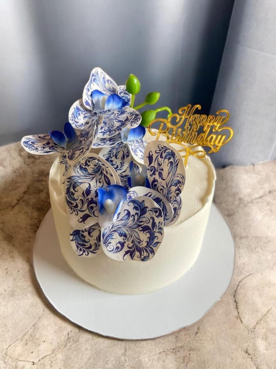 Blue and white floral birthday cake with hand-piped roses