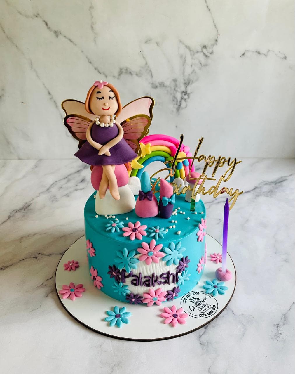 Fairy and rainbow birthday cake with pastel flowers