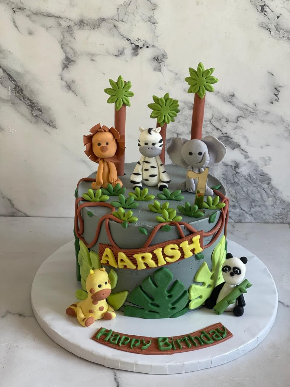 Jungle animal birthday cake with palm trees and fondant animals