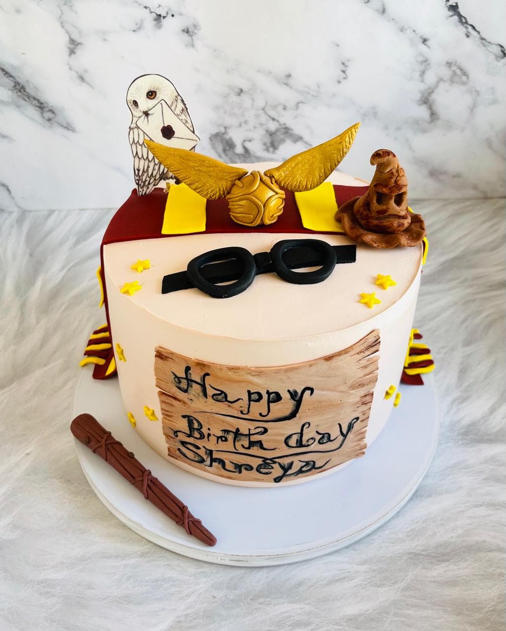 White birthday cake with sunglasses, a lion topper, and chocolate decorations