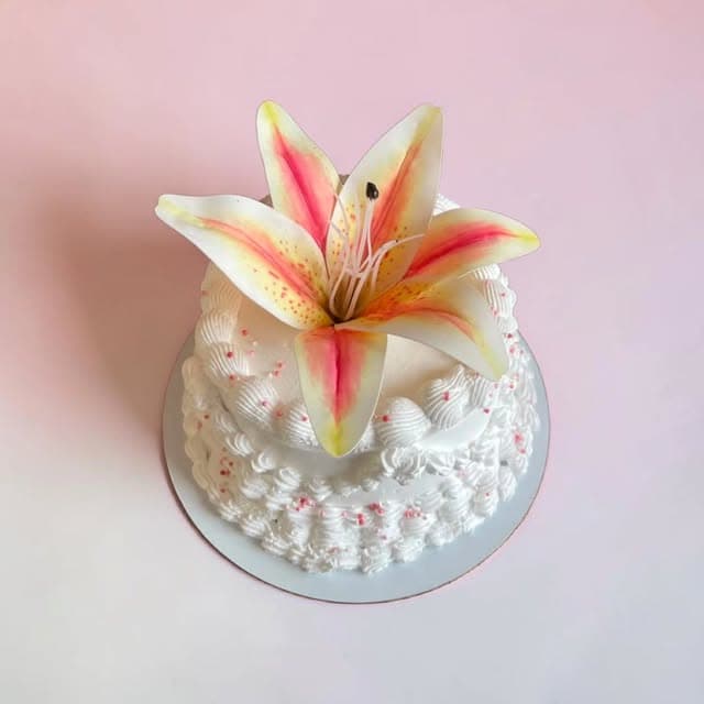 White floral cake with a pink lily