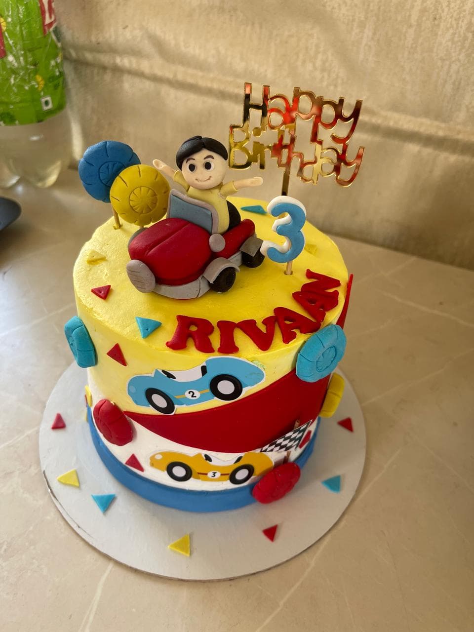 Colourful car-themed third birthday cake with fondant vehicle details